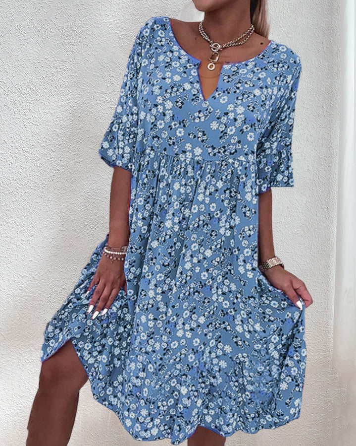 Woman wearing a blue floral dress against a white background