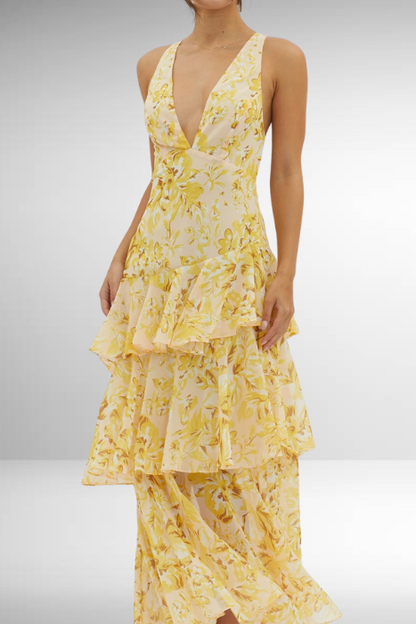 Yellow floral dress with ruffled layers on a plain background