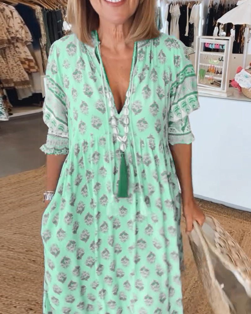 Woman wearing a green floral dress in a clothing store.