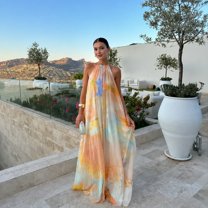 Woman in a colorful dress standing on a patio with scenic background
