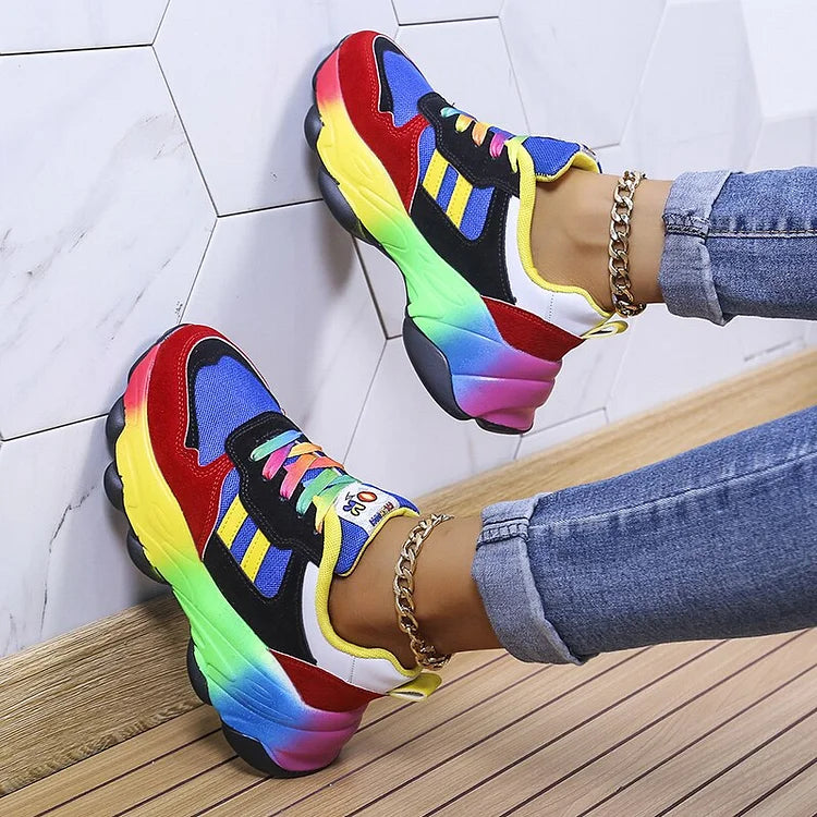 Colorful sneakers worn on a wooden floor with a white tiled wall background
