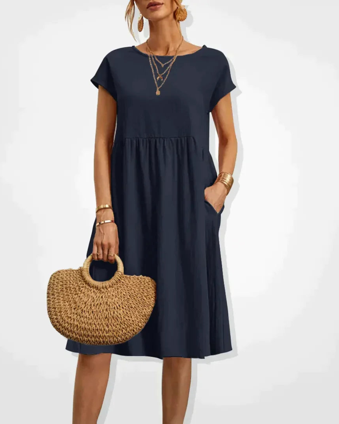 Woman wearing a black dress holding a woven handbag on a white background