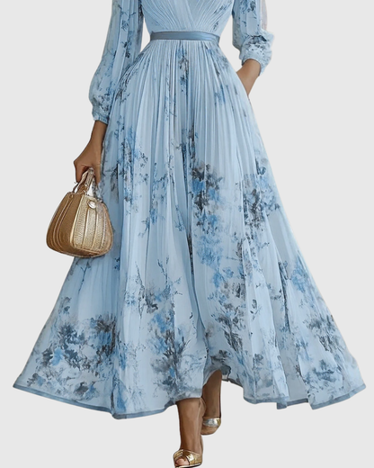 Woman wearing a blue floral dress holding a brown handbag on a white background