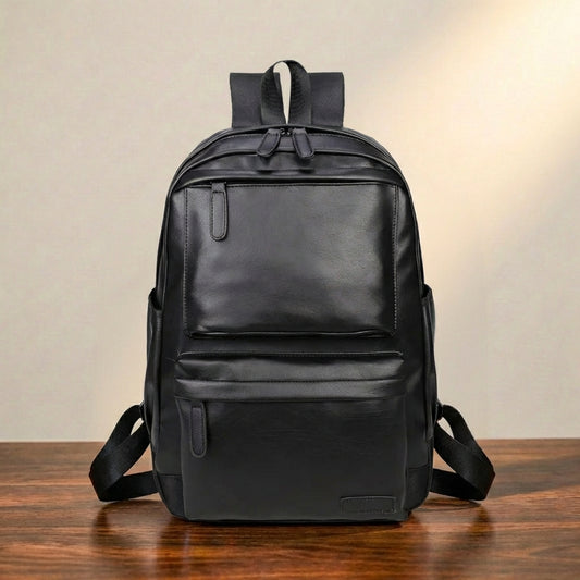 Black leather laptop backpack on a wooden surface with a neutral background