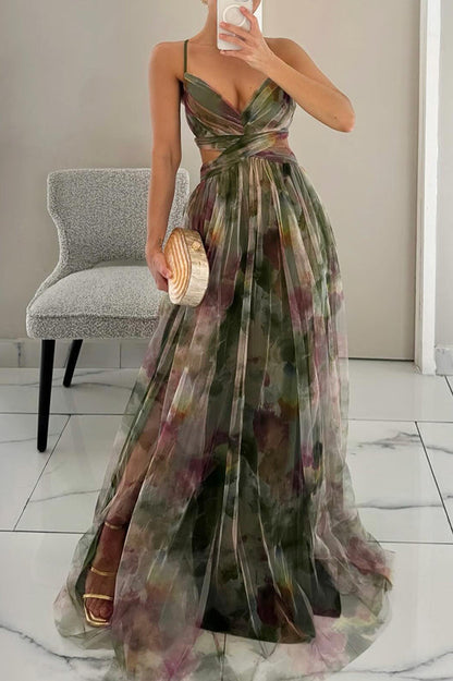 Woman wearing a floral dress holding a clutch in a room with a chair and white walls.