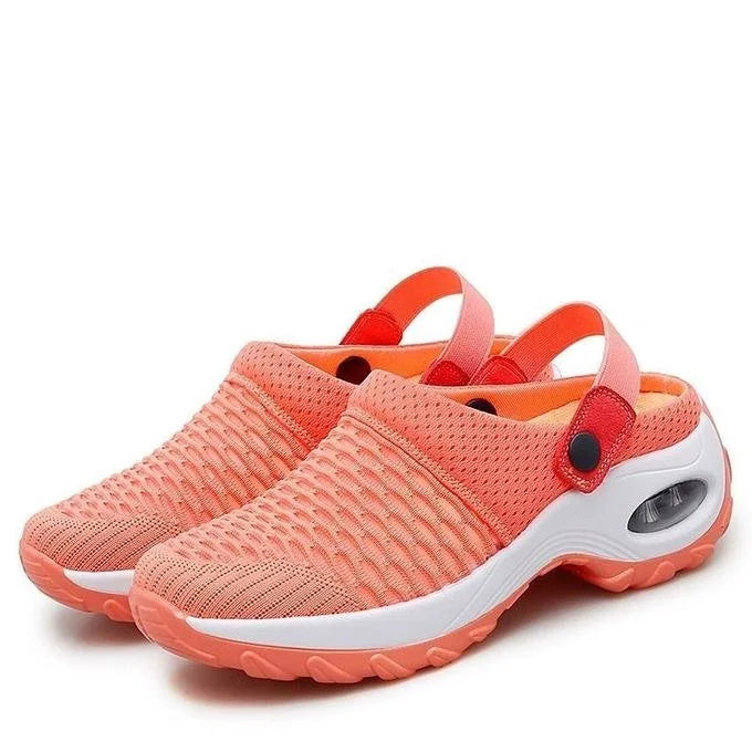 Pair of pink clogs with white soles on a white background