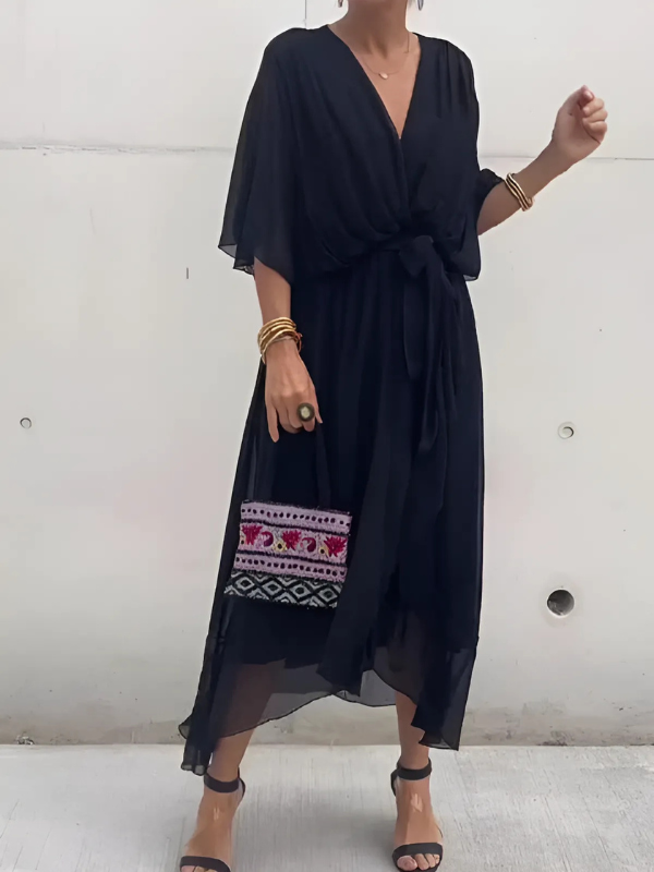 Woman wearing a black dress with embroidery on a white background