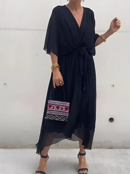 Woman wearing a black dress with embroidery on a white background