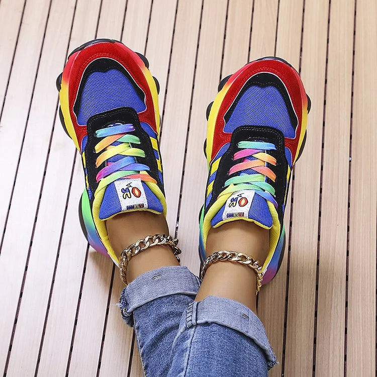 Colorful sneakers with rainbow laces on a wooden floor