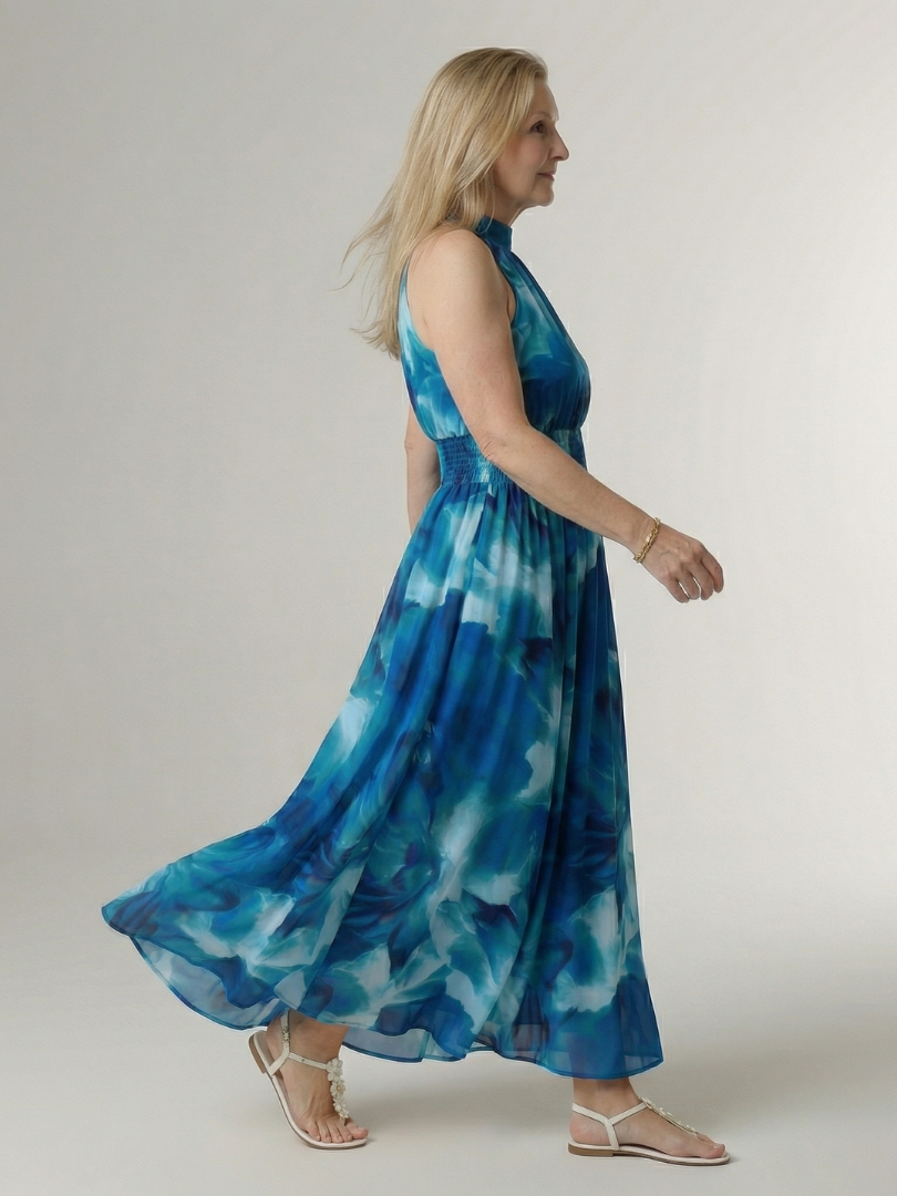 Woman wearing a blue tie-dye dress against a white background