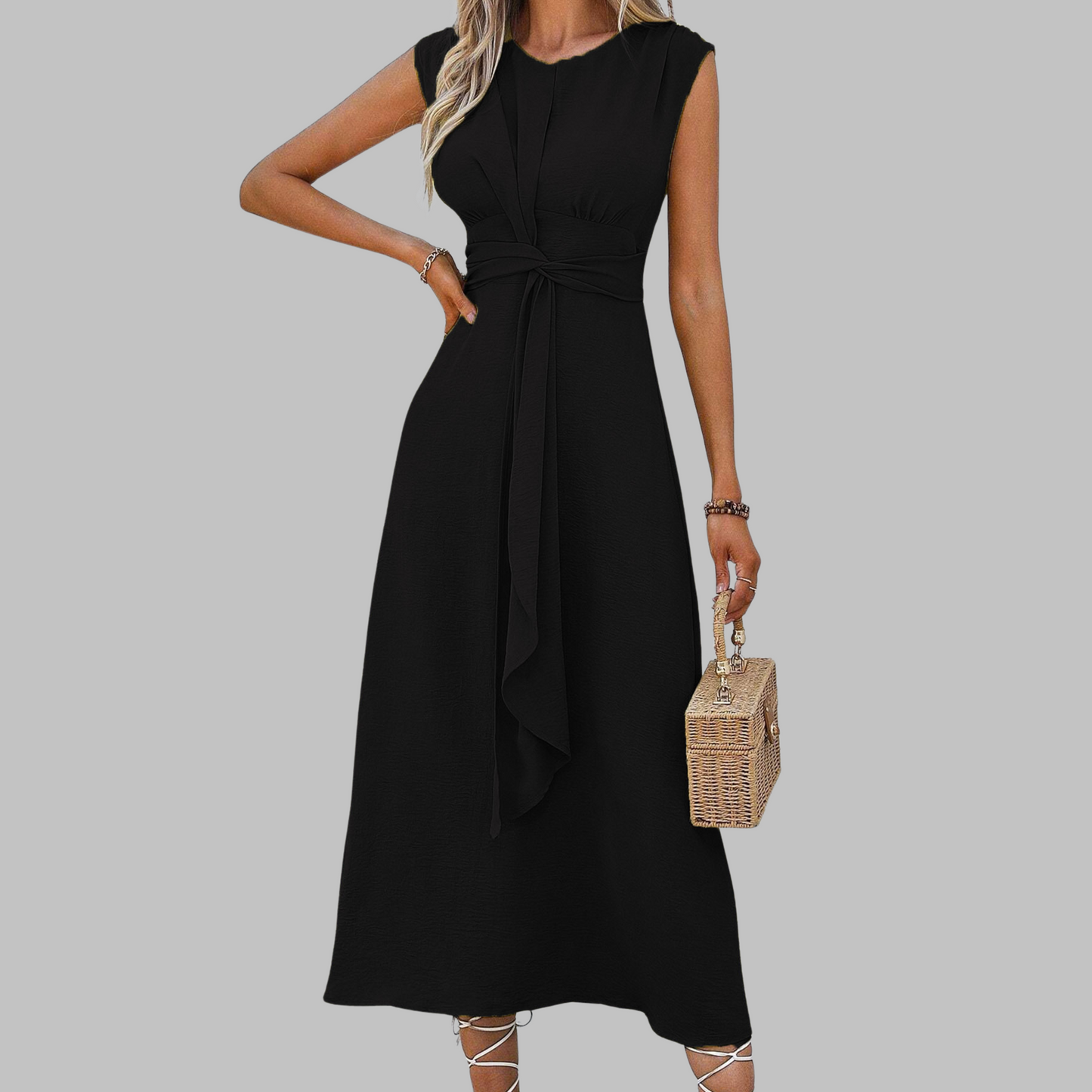 Woman wearing a black dress holding a woven handbag on a gray background