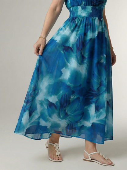 Woman wearing a blue floral dress on a plain background
