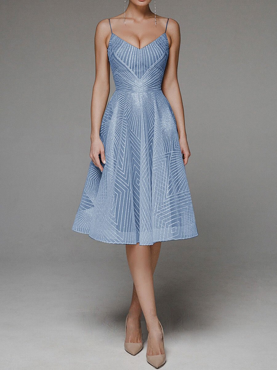 Woman wearing a blue dress with geometric pattern on a gray background