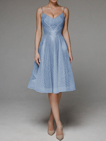 Woman wearing a blue dress with geometric pattern on a gray background