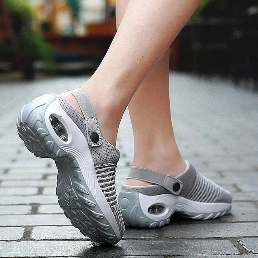 Gray clogs on feet standing on a pavement