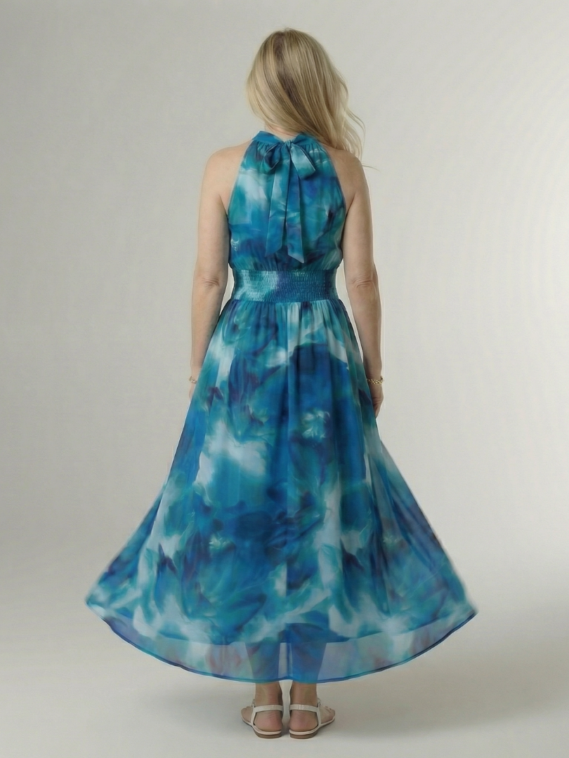 Woman wearing a blue floral dress against a plain background
