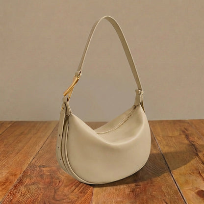 Beige leather purse on a wooden surface with a neutral background