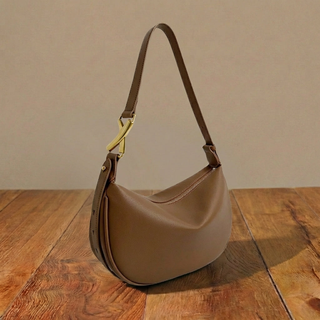 Brown mini purse with a gold clasp on a wooden surface