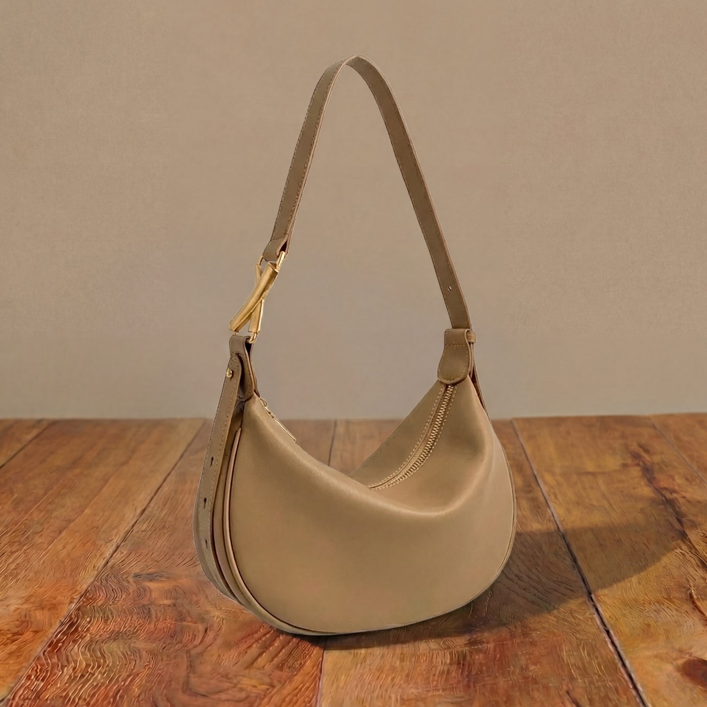 Light brown shoulder bag on a wooden surface with a neutral background
