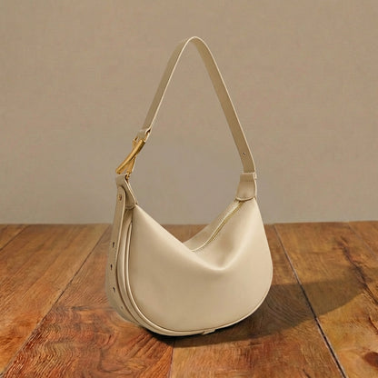White leather handbag on a wooden surface with a neutral background
