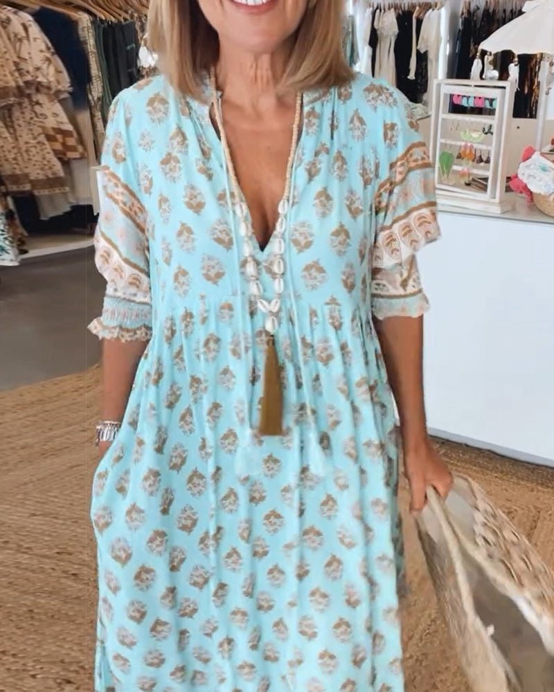 Woman wearing a light blue floral dress in a clothing store.