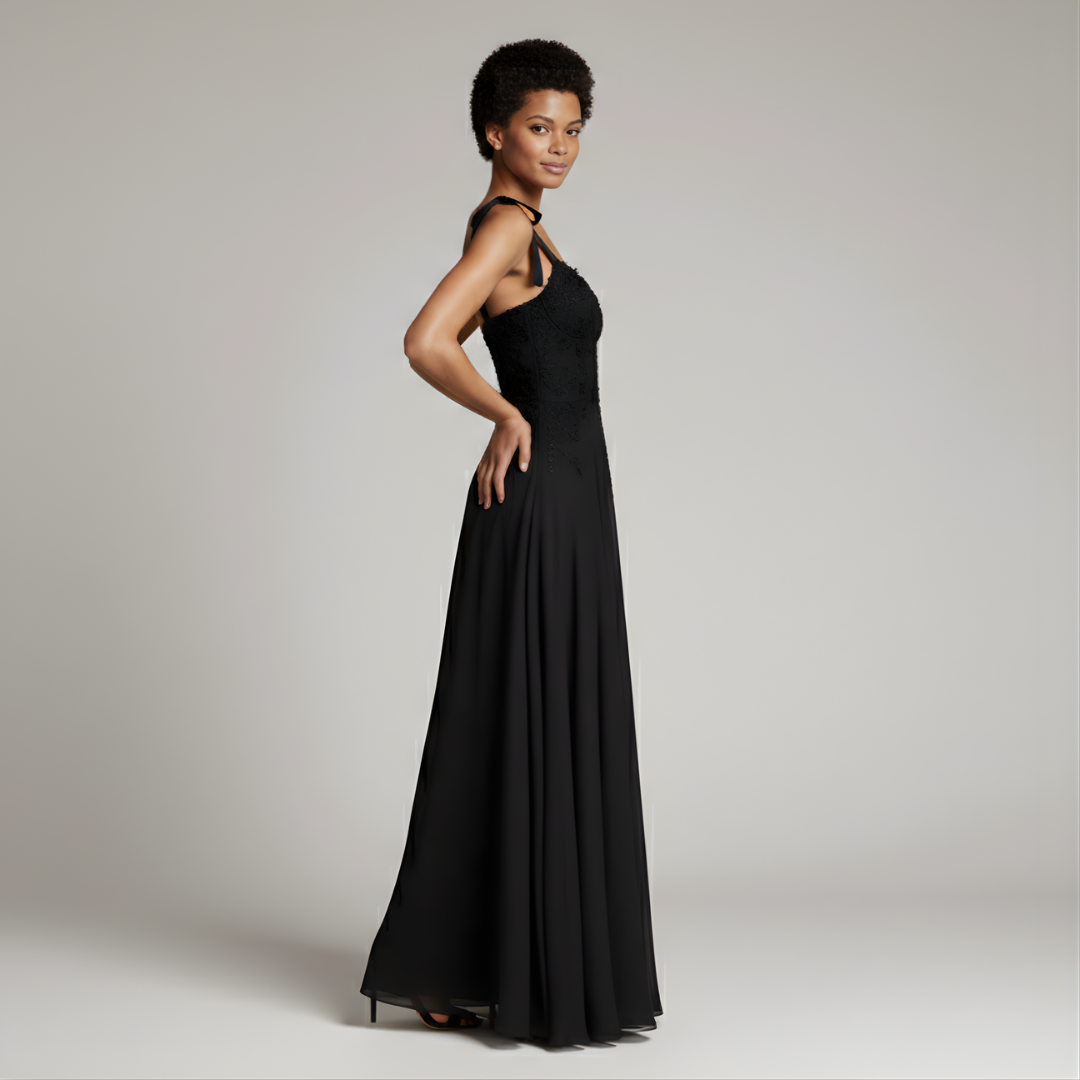 Woman wearing a black evening gown against a plain background