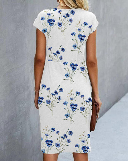 Woman wearing a white dress with blue floral pattern against a gray background