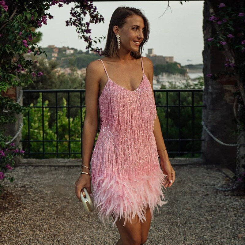 Woman in a pink dress standing outdoors with a scenic background