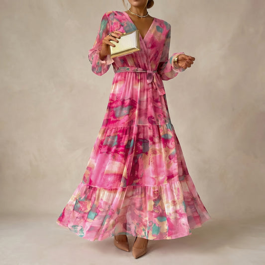 Woman wearing a pink floral dress holding a gold clutch against a beige background