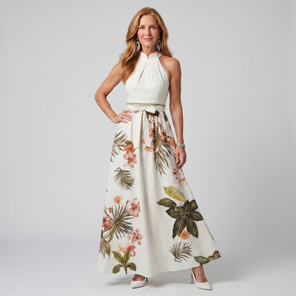 Woman wearing a white dress with floral patterns on a plain background