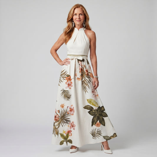 Woman wearing a white dress with floral patterns on a plain background