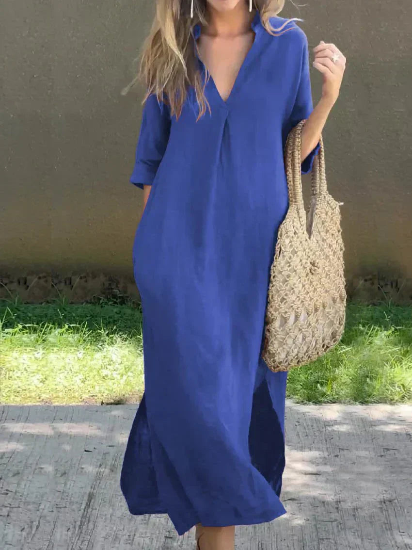Woman wearing a blue dress holding a straw bag against a neutral background