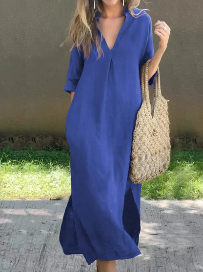 Woman wearing a blue dress holding a straw bag against a neutral background