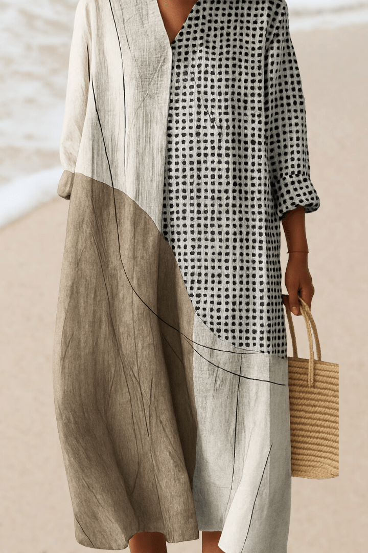 Person wearing a black and white checkered dress with a beige cover-up on a beach.