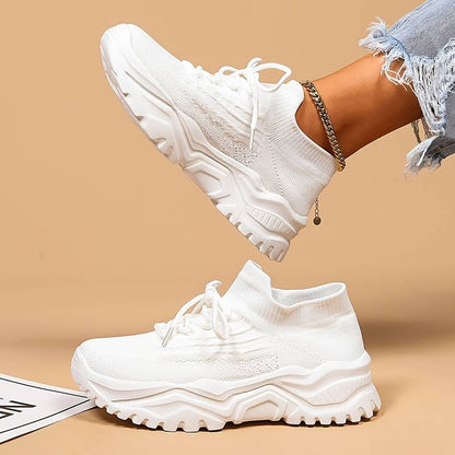 White sneakers worn with a beige background