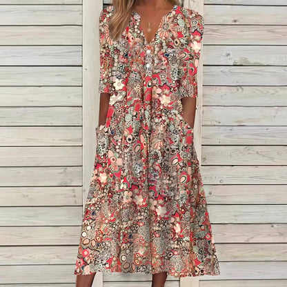 Woman wearing a floral dress standing against a wooden wall.