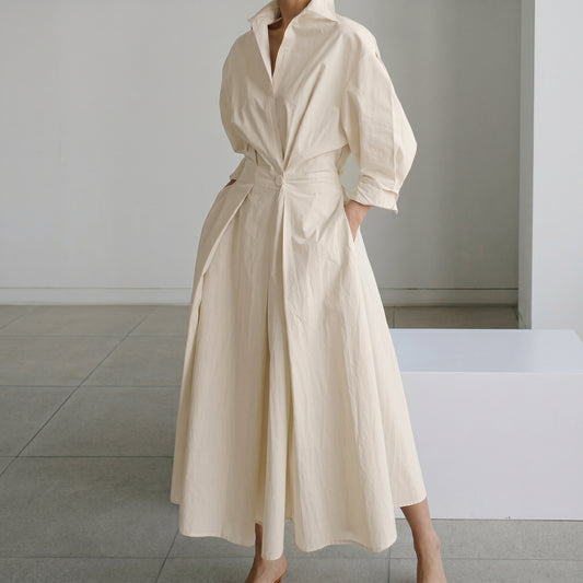Person wearing a beige dress in an indoor setting