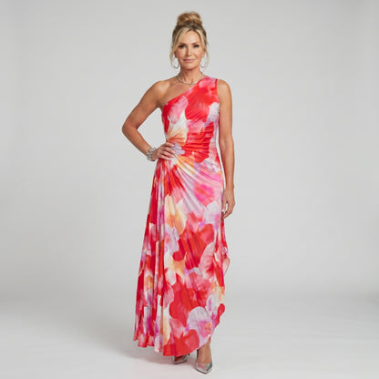 Woman wearing a colorful one-shoulder dress on a gray background