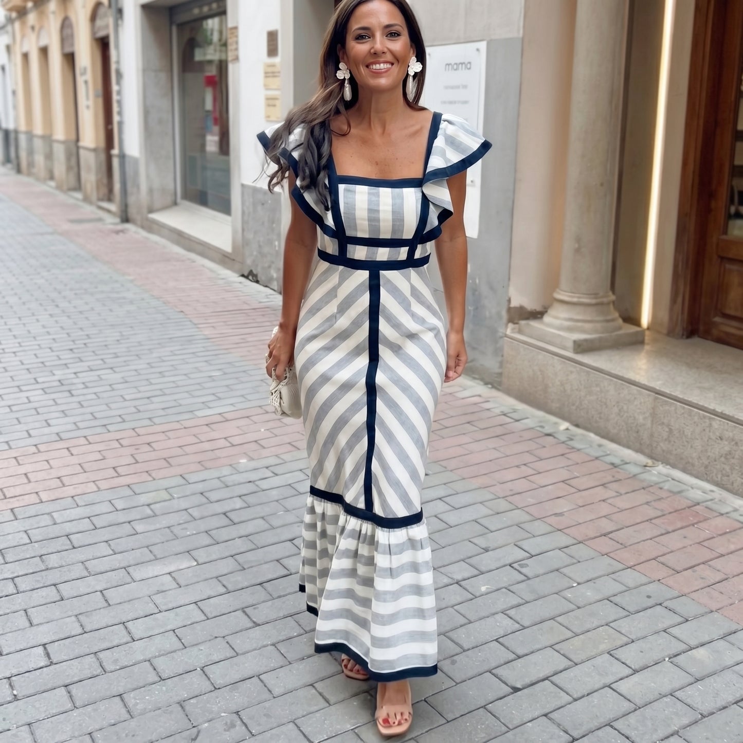 Woman in a striped dress walking on a city street