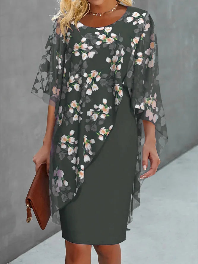 Woman wearing a dark floral dress with a brown clutch against a gray background