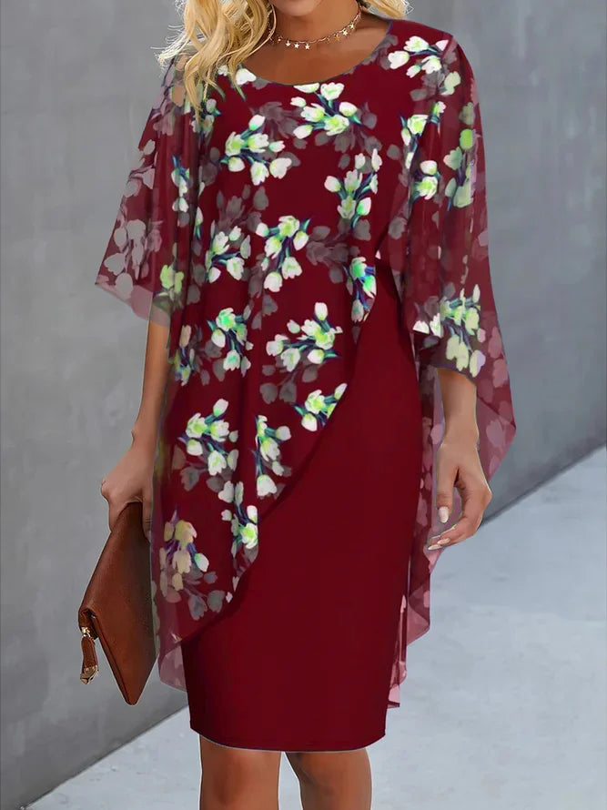 Woman wearing a burgundy dress with floral overlay against a gray background