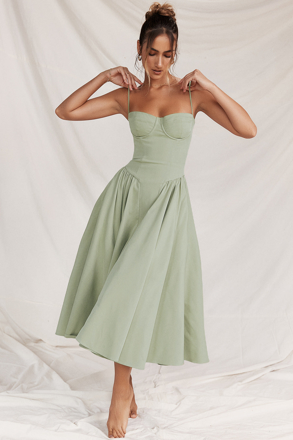 Woman wearing a light green dress against a neutral background
