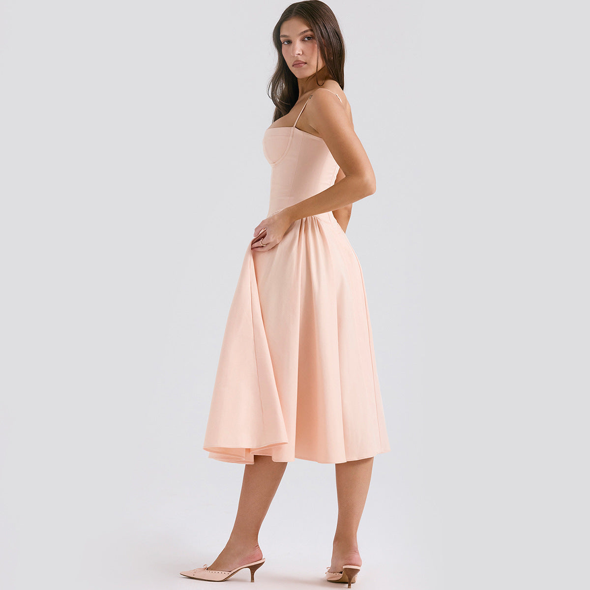 Woman wearing a light pink dress on a white background