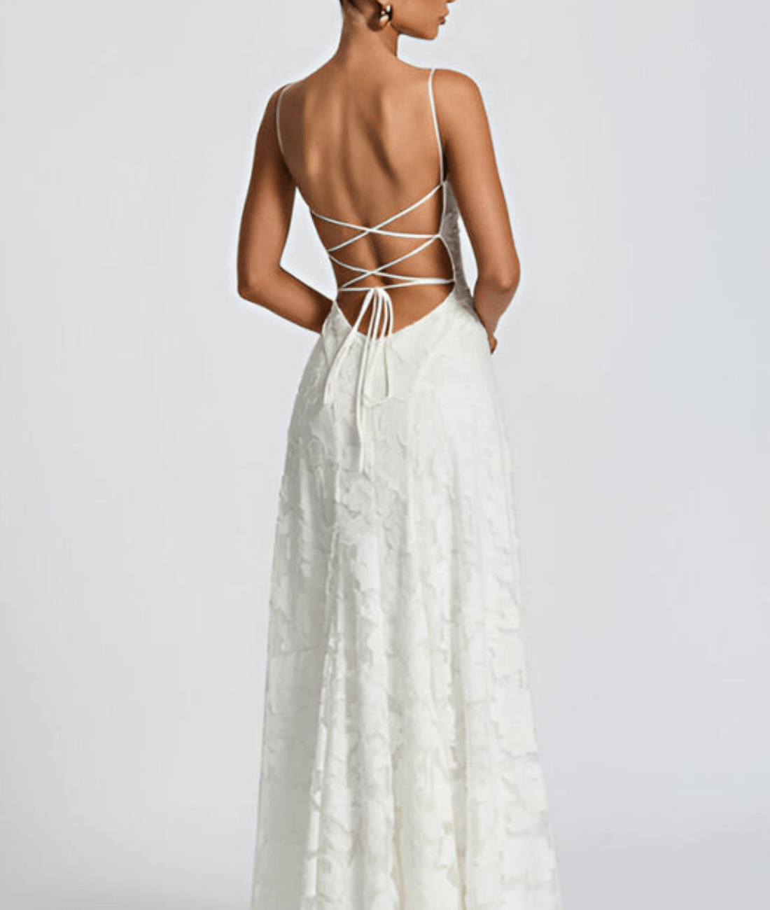 White dress with open back on a plain background