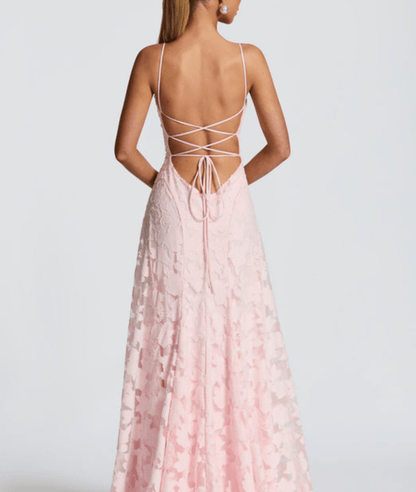 Pink lace dress with thin straps and open back on a plain background