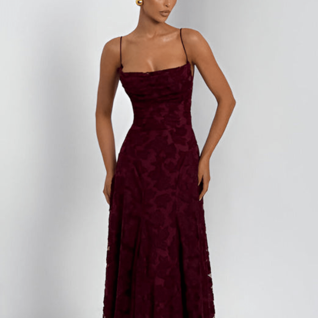 Burgundy evening gown on a model against a white background