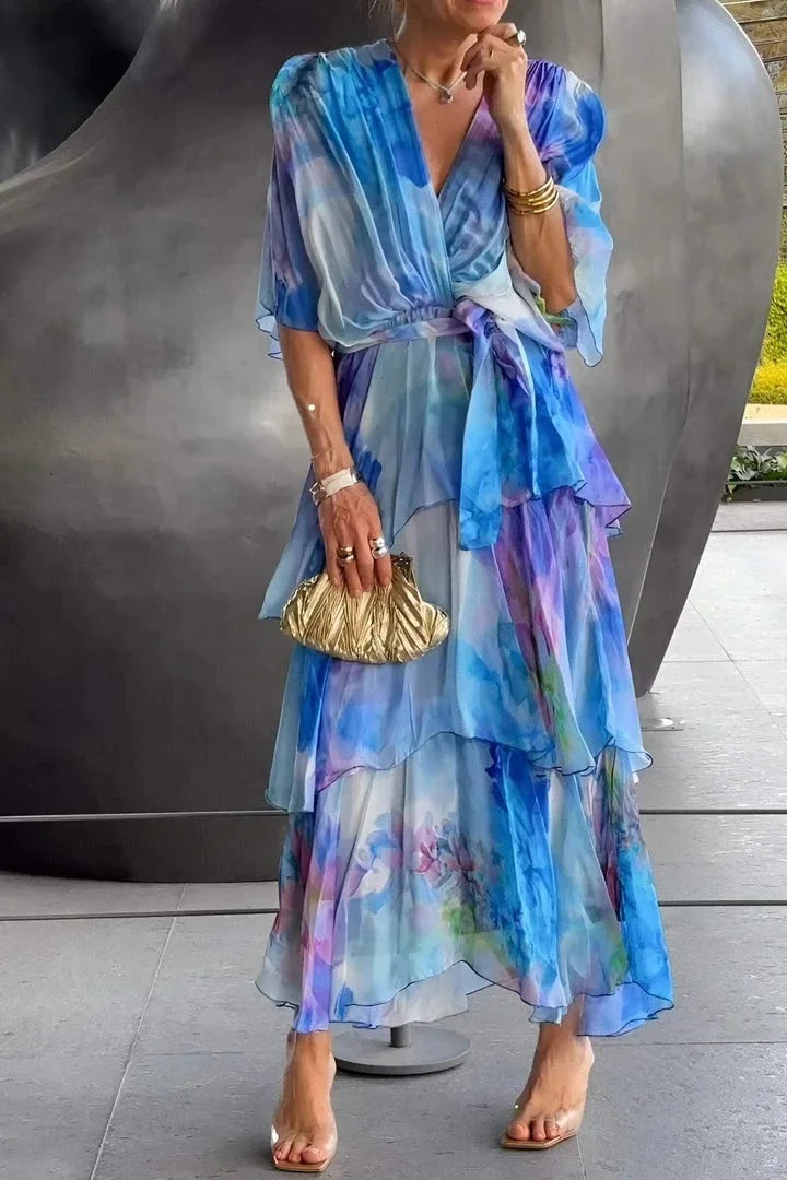 Woman wearing a colorful dress with a gold clutch in an urban setting