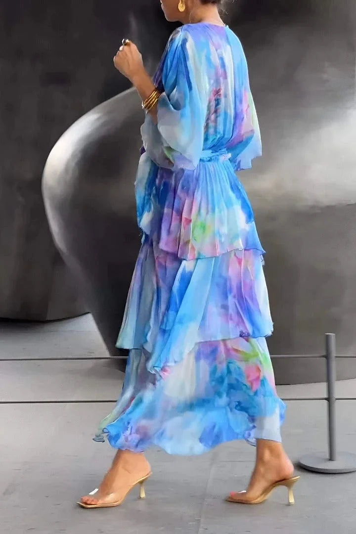 Woman wearing a colorful, tiered dress with a blurred background