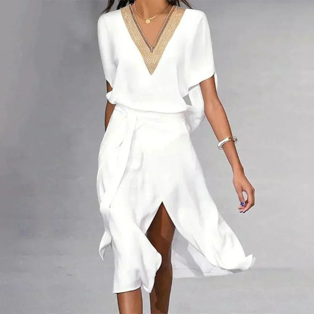 White dress with gold neckline on a gray background