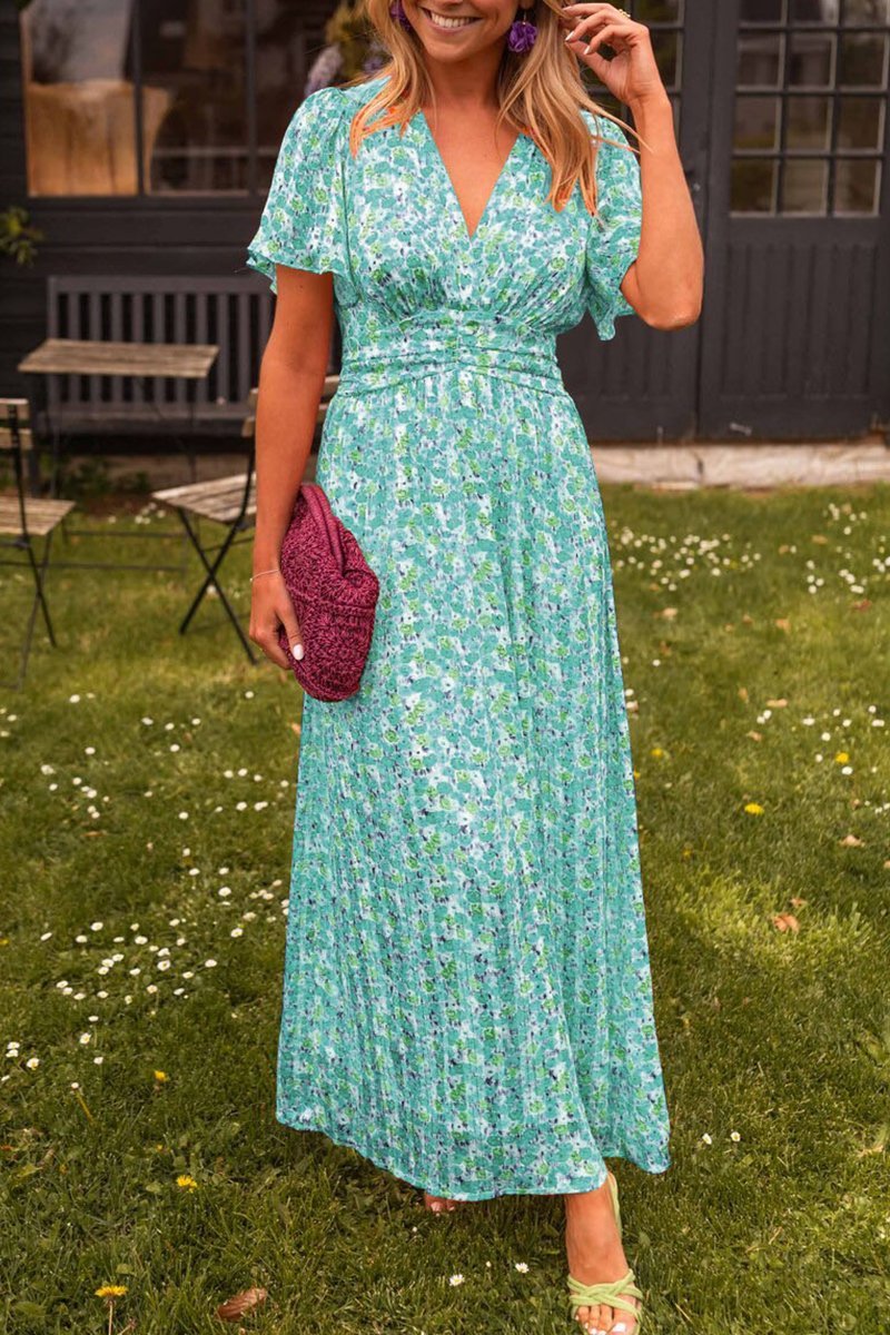 Woman in a green floral dress standing in a garden